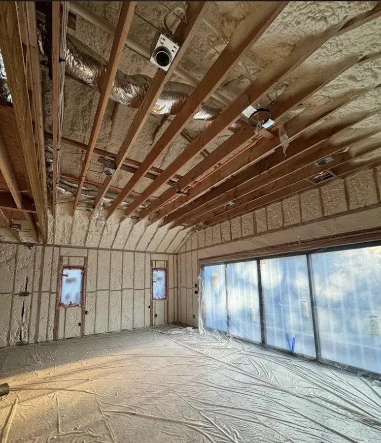 Interior walls and ceiling insulated with spray foam during new construction in Milan
